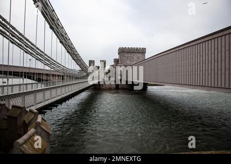 Stephensons Tubular Railway Bridge Telfords Hängebrücke und die neuere moderne Straßenbrücke über den Fluss Conwy mit Conwy Castle dahinter Stockfoto