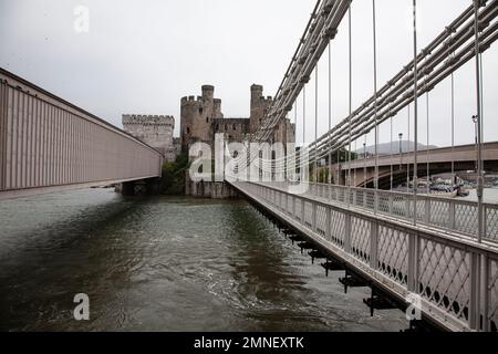 Telfords Hängebrücke Stephensons Tubular Railway Bridge und die neuere moderne Straßenbrücke über den Fluss Conwy mit Conwy Castle dahinter Stockfoto