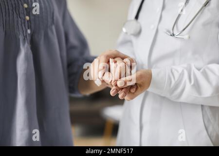 Covid-Heilzentrum-Ärztin, die ältere Patienten an den Händen hält. Hochauflösendes Foto Stockfoto