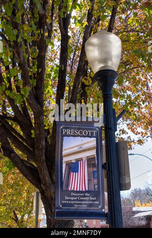 Prescott, AZ - 17. November 2022: Lampenbanner mit dem Yavapai County Court House und der Flagge der Vereinigten Staaten Stockfoto