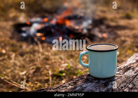 Fokussierter Kaffeebecher brannte am Lagerfeuer aus. Hochauflösendes Foto Stockfoto