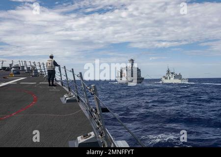 SÜDCHINESISCHES MEER (OKT 2, 2022) Arleigh Burke-Klasse Lenkraketen-Zerstörer USS Higgins (DDG 76), links, nähert sich Henry J. Kaiser-Klasse unterwegs Nachschuböler USNS Rappahannock (T-AO 204), Mitte, während er eine Nachschubflotte auf See mit der Royal Canadian Navy Halifax-Klasse Fregatte HMCS Windpeg (FFH 338) im Südchinesischen Meer, Oktober 2, durchführt. Higgins nimmt an multilateralen Übungen im Südchinesischen Meer zur Unterstützung des Indo-Pazifik-Einsatzes der japanischen Maritime Self-Defense Force zusammen mit der Royal Canadian Navy Teil. Routinemäßige multilaterale Übungen wie diese stärken die Interoperabilität Stockfoto