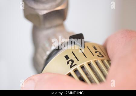 Hand auf den Heizthermostat, Deutschland Stockfoto