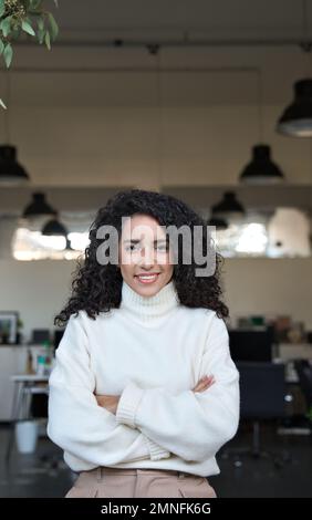 Junge geschäftsfrau aus lateinamerika, die im Büro steht, vertikales Porträt. Stockfoto