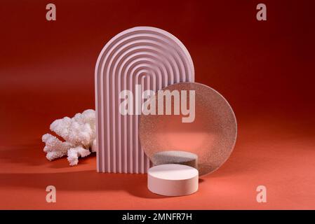 Zusammensetzung geometrischer Podien oder Sockel in schmutzigem Rosa gegen Rot. Minimaler Hintergrund für die Präsentation kosmetischer Mittel. Stockfoto