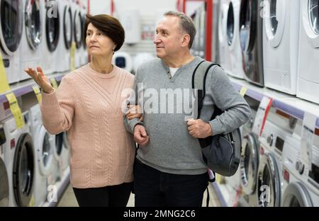 Europäische Ehegatten im reifen Alter entscheiden sich für eine Waschmaschine Stockfoto