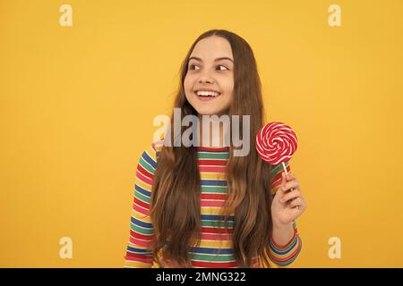 Hipster Teenager Kind Mädchen lecken Lollypop. Zucker Ernährung, Süßigkeiten und Süßigkeiten. Kind isst Lollipop-Popsicle. Stockfoto