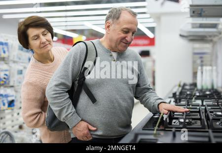 Frau und Mann mittleren Alters pflücken einen neuen Gasherd im Laden Stockfoto