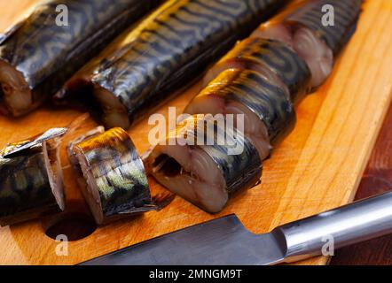 Scheiben von heißer geräucherter Makrele auf Holzfläche Stockfoto