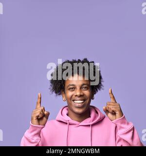 Ein lächelnder afrikanischer Teenager, der ein neues Werbeangebot präsentiert. Schließen Stockfoto