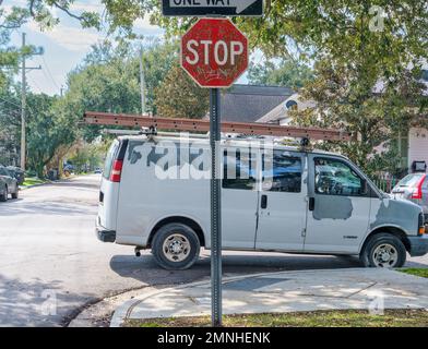 NEW ORLEANS, LA, USA - 30. JANUAR 2023: Der Lieferwagen eines Bauunternehmers parkt illegal an der Ecke einer Uptown-Nachbarschaft Stockfoto