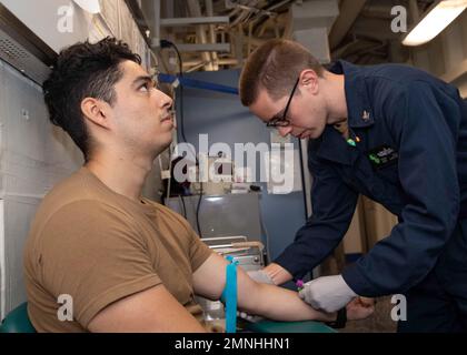 Ein Sanitäter des Krankenhauses, dem Flottenchirurgenteam (FST) 4 zugewiesen, nimmt Blut von einem Techniker für Luftfahrt-Support-Ausrüstung 3. Klasse Ca. 2020 Stockfoto