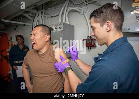 Senior Chief Staff Specialist, dem Amphibienschiff USS Bataan (LHD 5) zugewiesen, erhält eine Anthrax-Impfung ca. 2020 Stockfoto