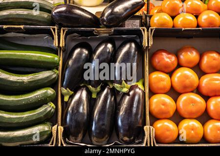 Farbenfrohes Bio-Sommergemüse, Tomaten, Zucchini und Auberginen in Schachteln, die auf dem lokalen Obst- und Gemüsemarkt verkauft werden Stockfoto