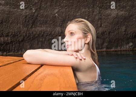 Schöne Frau, die sich im Teich entspannt Stockfoto