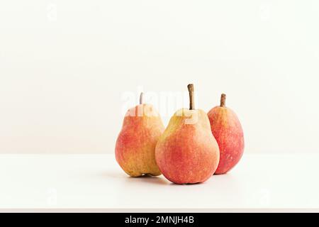 Drei reife comice-Birnen auf einem weißen Holzbrett Stockfoto