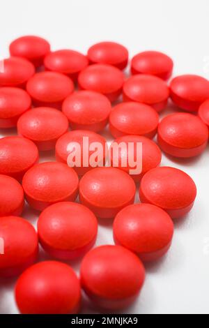 Rote Arzneimittelpillen auf weißem Hintergrund. Stockfoto