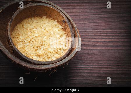 Braunes Reisgelb, für Risotto auf einem Holzbrett Stockfoto