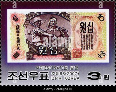 Nordkoreanische Briefmarke aus dem Jahr 2007 mit einer Banknote aus 1947 10 Won mit Farmer- und Arbeitermotiven, DVRK-Philatelie. Stockfoto
