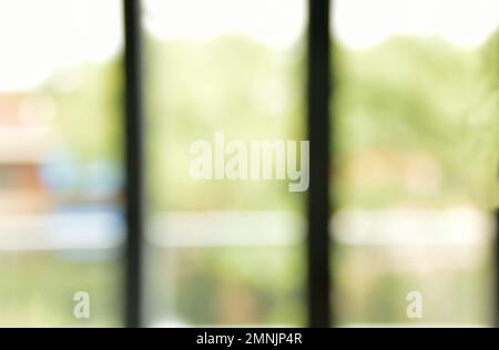 Verschwommenes Bürofoto mit Fenster und Blick auf den Wald Stockfoto