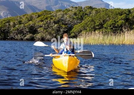 Südafrika, Stanford, Junge und Teenager Mädchen (10-11, 16-17) Kajakfahren in der Lagune Stockfoto