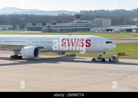 Zürich, Schweiz, 19. Januar 2023 Internationale Schweizer Fluggesellschaften Boeing 777-300-er wird entlang des Vorfelds gezogen Stockfoto
