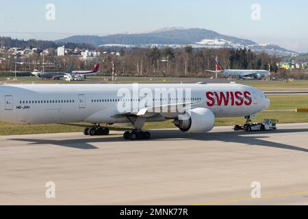 Zürich, Schweiz, 19. Januar 2023 Internationale Schweizer Fluggesellschaften Boeing 777-300-er wird entlang des Vorfelds gezogen Stockfoto