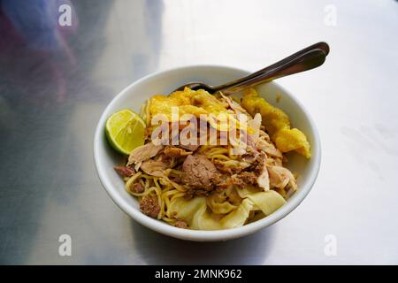 Mie Ayam. Indonesisches lokales Essen Hühnchen Nudeln und Soße in separaten Schalen Stockfoto