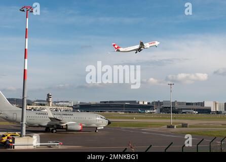 Zürich, Schweiz, 19. Januar 2023 der schweizerische Airbus A330-343 startet hinter einem kolumbianischen Regierungsflugzeug 737-700, das während des Arbeitsauftrags geparkt ist Stockfoto