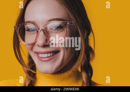 Foto einer fröhlichen jungen, fröhlichen Frau, die eine lächelnde Brille trägt, ein Gesicht mit guter Laune, isoliert auf gelbem Hintergrund Stockfoto