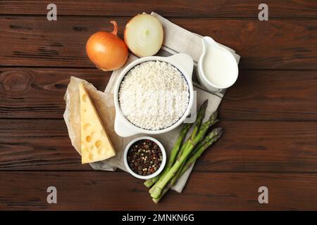 Flache Liegezusammensetzung mit verschiedenen Zutaten auf Holztisch. Risotto-Rezept Stockfoto