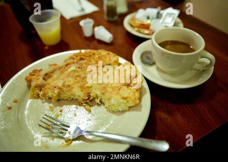 Halb gegessen Matzo-Mehl mit Kaffee und Gabel auf weißem Geschirr im Diner Stockfoto