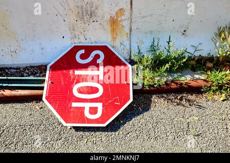 Stoppschild liegt auf der Straße neben Barrier, Center of Frame Stockfoto