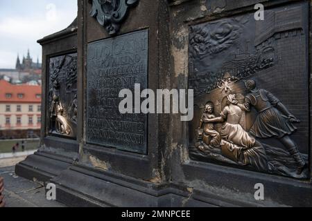 Religiöses Symbol der Bronzelöschung unter der Statue des Heiligen Johannes von Nepomuk, Karlsbrücke, Prag, Tschechische Republik Stockfoto