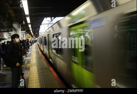 Japanische Passagiere warten auf die JR Yamanote-Linie in Tokio, Japan. Stockfoto