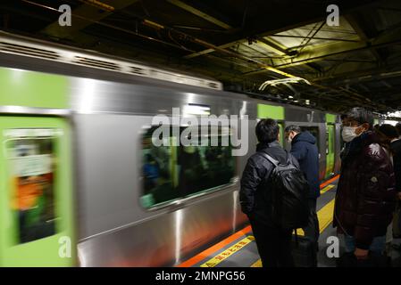 Japanische Passagiere warten auf die JR Yamanote-Linie in Tokio, Japan. Stockfoto