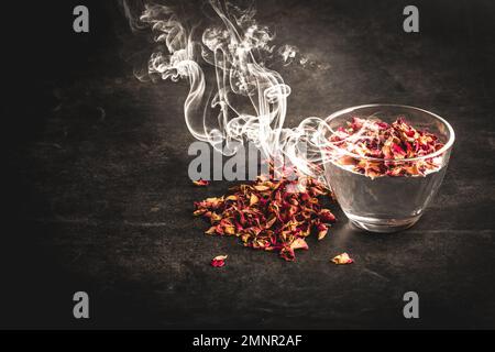 Rose Tea in transparentem Glas auf schwarzem Hintergrund Stockfoto