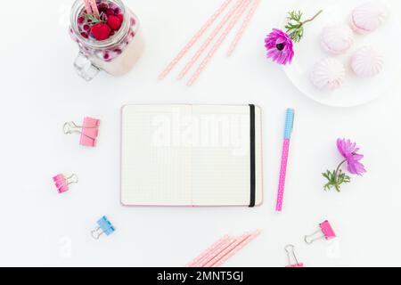 Beeren-Smoothie mit Pailletten, Marshmallow und pinkfarbenen Anemonen mit Kopierbereich auf weißem Hintergrund. Flach verlegt. Stockfoto