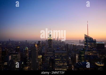 Vom Gipfel des Rockefeller Centre aus blickt man in Richtung Süden über die Wolkenkratzer von Manhattan, wobei das Empire State Building im Mittelpunkt steht. Stockfoto