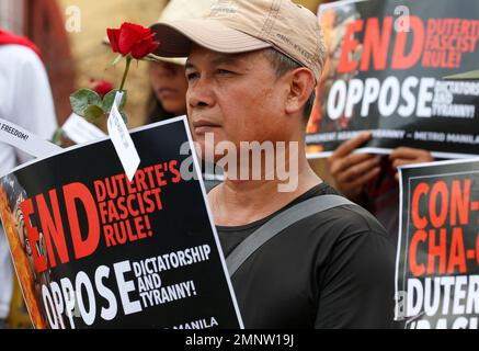 Protesters hold red roses while displaying placards during a rally near the Presidential Palace to mark the 32nd anniversary of the 'People Power' revolution Sunday, Feb. 25, 2018 in Manila, Philippines. The protesters scored President Rodrigo Duterte, who skipped the ceremony for the second straight year Sunday, for his 'creeping dictatorship' and are demanding for his ouster. (AP Photo/Bullit Marquez)