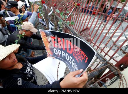 Protesters hang placards and flowers on a barbed wire barricade leading to the Presidential Palace during a rally near the Presidential Palace to mark the 32nd anniversary of the 'People Power' revolution Sunday, Feb. 25, 2018 in Manila, Philippines. The protesters scored President Rodrigo Duterte, who skipped the ceremony for the second straight year Sunday, for his 'creeping dictatorship' and are demanding for his ouster. (AP Photo/Bullit Marquez)