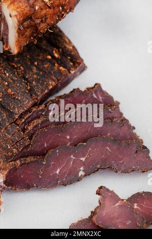 Frisch geschnittene südafrikanische Biltong auf hellem Hintergrund mit selektivem Fokus und Kopierbereich Stockfoto