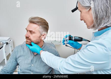 HNO-Arzt zur Untersuchung des Erwachsenenohrs mit Endoskop an der Hals-Nasen-Ohren-Klinik. Ohrendoskopie Stockfoto