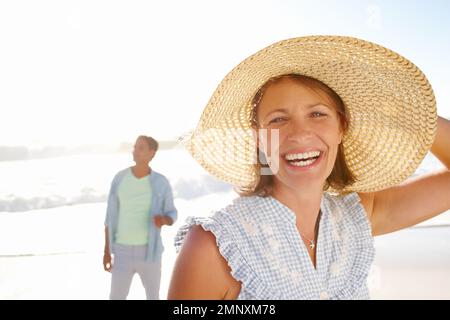 Überglücklich und frei. Porträt einer glücklichen Frau, die mit ihrem Mann am Strand spazieren geht. Stockfoto