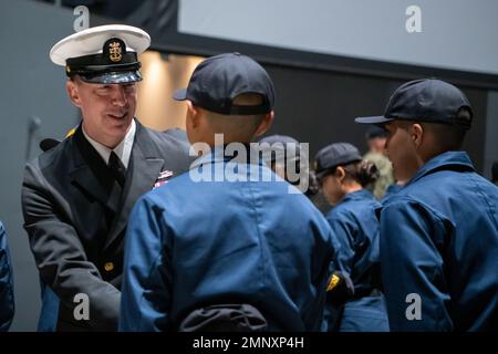 Force Master Chief Jason Dunn, Force Master Chief, Commander Navy Installations Command, gratuliert den Matrosen nach ihrer Deckungszeremonie auf dem Pier der USS Trayer (BST 21) beim Recruit Training Command. Trayer, besser bekannt als „Kampfstationen“, ist das Schmelztiegel-Ereignis, das Rekruten vor ihrem Abschluss passieren müssen und ihr Wissen und ihre Fähigkeiten in grundlegenden Seemannschaft, Schadenskontrolle, Brandbekämpfung, Wachdienst und Notfallmaßnahmen testen müssen. Mehr als 40.000 Rekruten trainieren jährlich im einzigen Bootcamp der Marine. Stockfoto