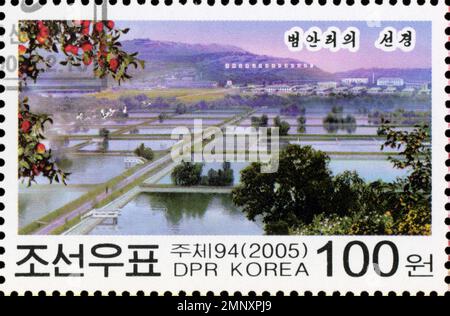 Nordkoreanische Briefmarke aus dem Jahr 2005, die eine malerische Landschaft von Beoman-ri mit Reisfeldern, Bergen und Apfelbäumen darstellt. Stockfoto