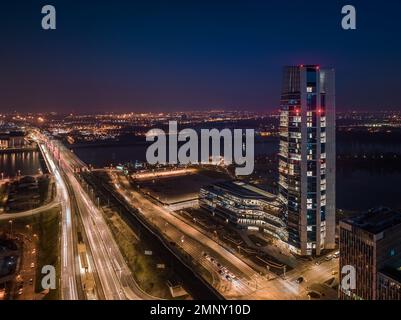 Budapest, Ungarn - Blick aus der Vogelperspektive auf den MOL Campus, Budapests neues, beleuchtetes Wolkenkratzer-Gebäude mit Rakoczi-Brücke über der Donau in der Abenddämmerung Stockfoto