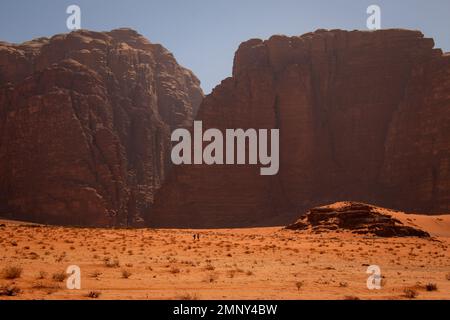 Zwei winzige Wanderer in der Wadi Rum Wüste, Jordanien, April Stockfoto