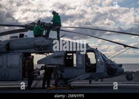 Segler, die den „Tridenten“ des Helicopter Sea Combat Squadron (HSC) 9 zugeordnet sind, führen tägliche Vorflugkontrollen an einem MH-60s Knighthawk auf dem Flugdeck des First-in-Class-Flugzeugträgers USS Gerald R. Ford (CVN 78) durch, 7. Oktober 2022. Die Gerald R. Ford Carrier Strike Group (GRFCSG) wird im Atlantischen Ozean eingesetzt und führt zusammen mit NATO-Alliierten und Partnern Trainings und Operationen durch, um die Integration für zukünftige Einsätze zu verbessern und das Engagement der US-Marine für eine friedliche, stabile und konfliktfreie atlantische Region zu demonstrieren. Stockfoto