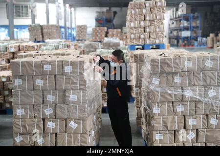 Mitarbeiter sortieren und packen Lehrbücher für das neue Semester im Xinhua Bookstore in Qingdao, Ostchina Provinz Shandong, 31. Januar 2023. Mit dem Beichtwort Stockfoto